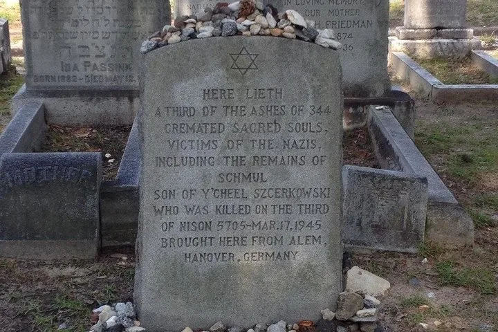Jüdischer Gedenkgrabstein auf einem Friedhof mit darauf abgelegten Steinen