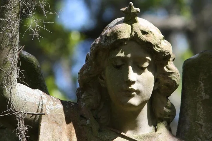 Nahaufnahme einer verwitterten Steinengelstatue mit einem Stern auf dem Kopf